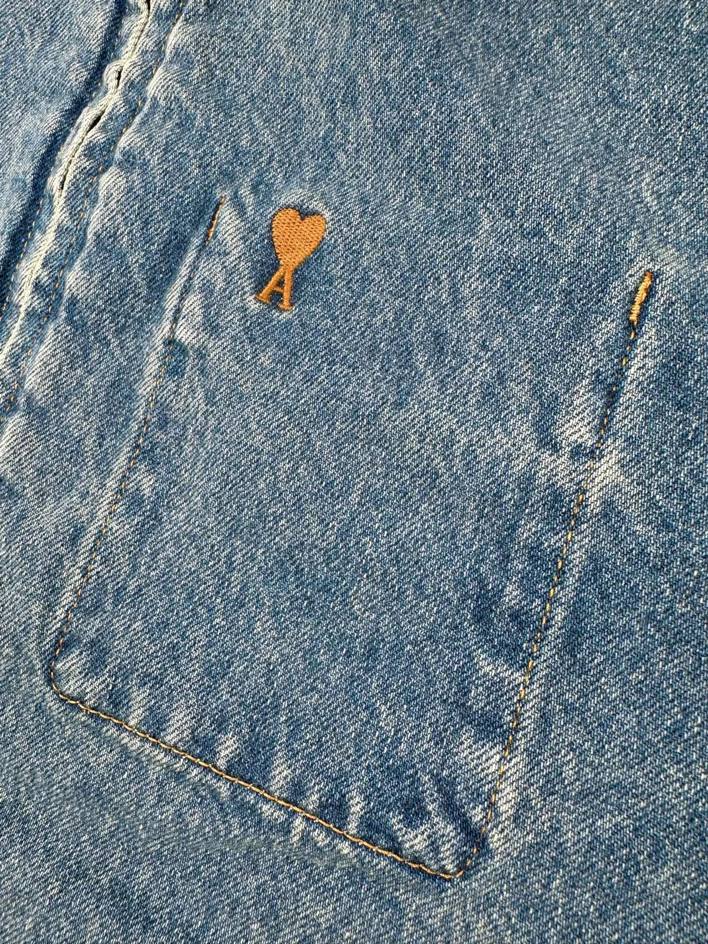 AP 265 Ami Paris embroidered denim jacket. Customized French mist washed denim. Stiff and stylish. Comfortable and soft. Made of distressed matte blue. The color is clear and elegant. Comes with soft light filter. Gold Brown love logo embroidery on the chest pocket looks like a gilt luxury seal. Low-key brand recognition. Vertical pockets on both sides hide practical ingenuity. Hem and cuffs are neatly trimmed with top-stitched edges. Retro workwear style is natural. The low-key decoration of the Cowhide Leather card on the back reveals French craftsmanship in the details. French relaxation and street elegance coexist and blend, creating a calm and graceful elegant family style. Process 1: Using imported machine embroidery technology. Using advanced computer control systems and precision mechanical components to achieve Ami love embroidery work with high precision and smooth and delicate lines. Process 2: Stone grinding, light fermentation, peeling, bleaching and softening. The mutual friction between pumice and clothing causes wear and fading effects on the surface of the denim. The combination of pulling and bleaching allows the clothing to produce a certain texture and stretching effect while bleaching. Process 3: Fried snowballs. Fried salt. Specially prepared corresponding solution. Add a certain amount of dye. Soak the denim material in it to absorb the solvent. Then scrub and dry to further fade and oxidize. Accessories: Customized 1:1 Ami zipper. Customized 1:1 Ami I-shaped buckle. Customized 1:1 Ami. Cowhide Leather playing cards customized 1:1 Ami trademark version: loose version Size: S M L XL Style number: BB 877